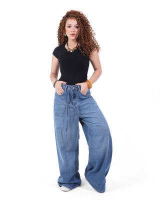 Woman in wide-leg blue jeans and black top posing for Jeanzy E-Commerce apparel